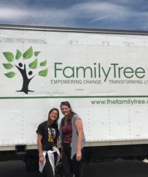 Two women smiling in front of a white delivery truck with "family tree" and a tree logo displayed, and website url below.