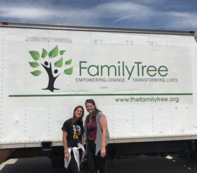 Two women smiling in front of a white delivery truck with "family tree" and a tree logo displayed, and website url below.