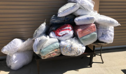 A pile of blankets and pillows on top of a table.