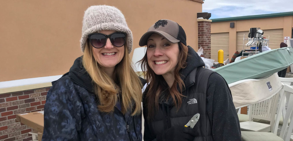 Two women standing next to each other outside.