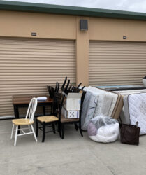 A pile of furniture sitting outside of a storage unit.