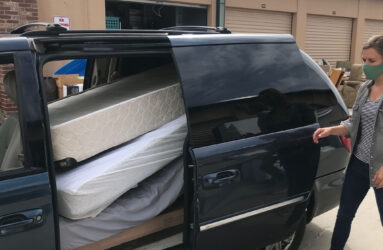 A man loading a truck with mattresses.