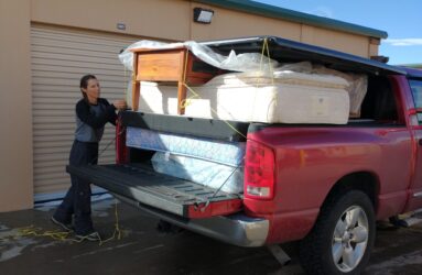 A man loading furniture into the back of his truck.