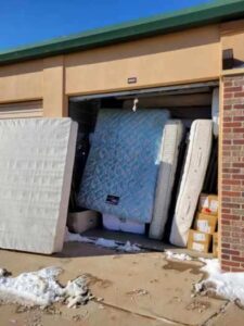A garage with mattresses and boxes in it