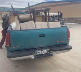 A truck with furniture in the back of it.