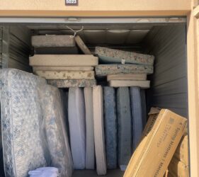 A storage unit filled with mattresses and boxes.