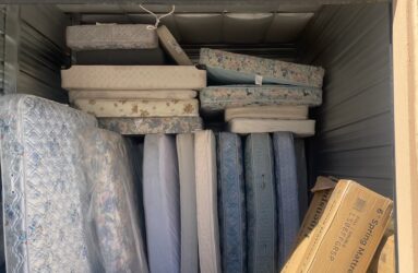 A storage unit filled with mattresses and boxes.