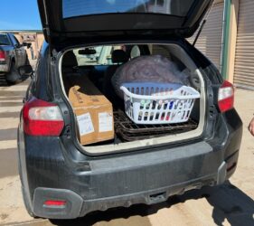 A car with the trunk open and some boxes in it