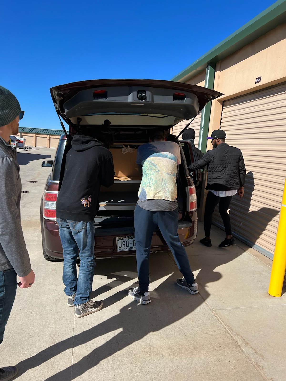 A group of people loading boxes into the back of a van.
