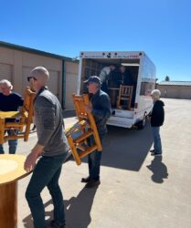 A group of men loading chairs into a moving truck.