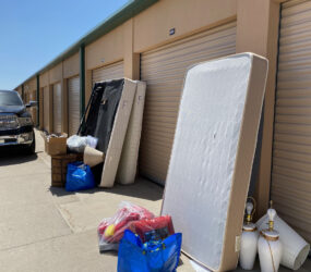 A pile of mattresses and other items outside.