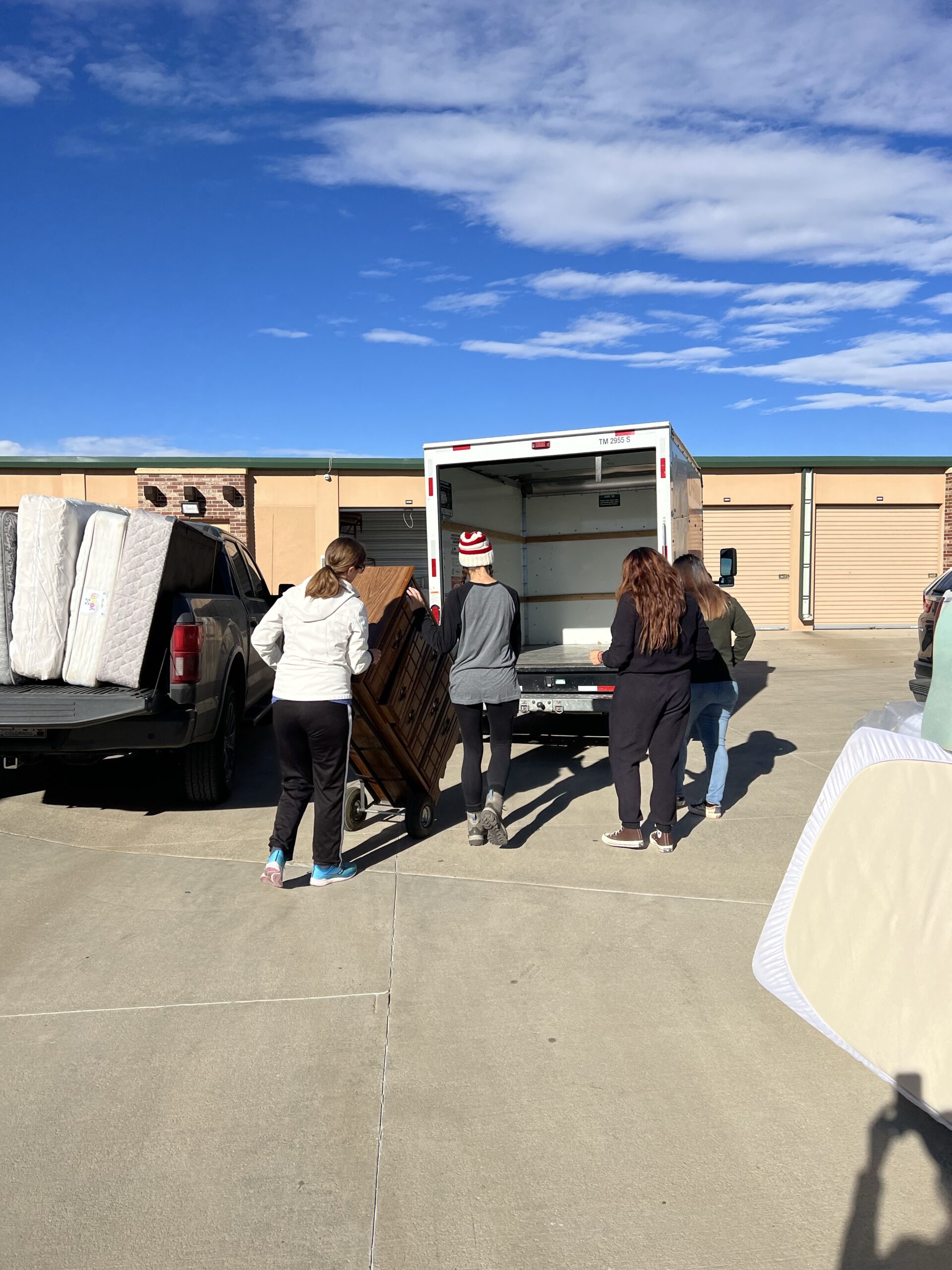 A group of people loading furniture into the back of a truck.