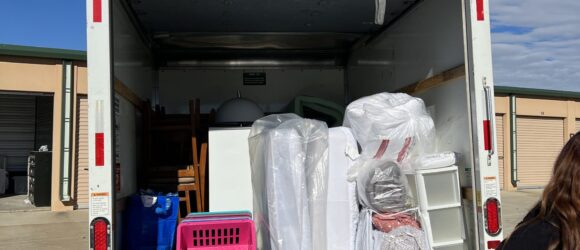 A woman standing in the back of a moving truck.