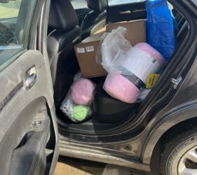 A car with many bags of items in the back.