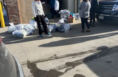 A group of people standing around some garbage.