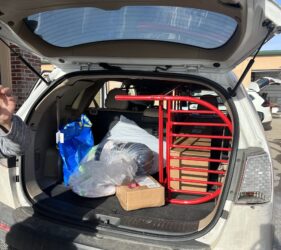 A car trunk with the back door open and a bunch of items in it.