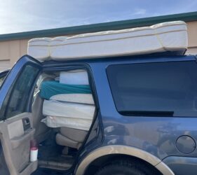 A van with mattress on the back of it